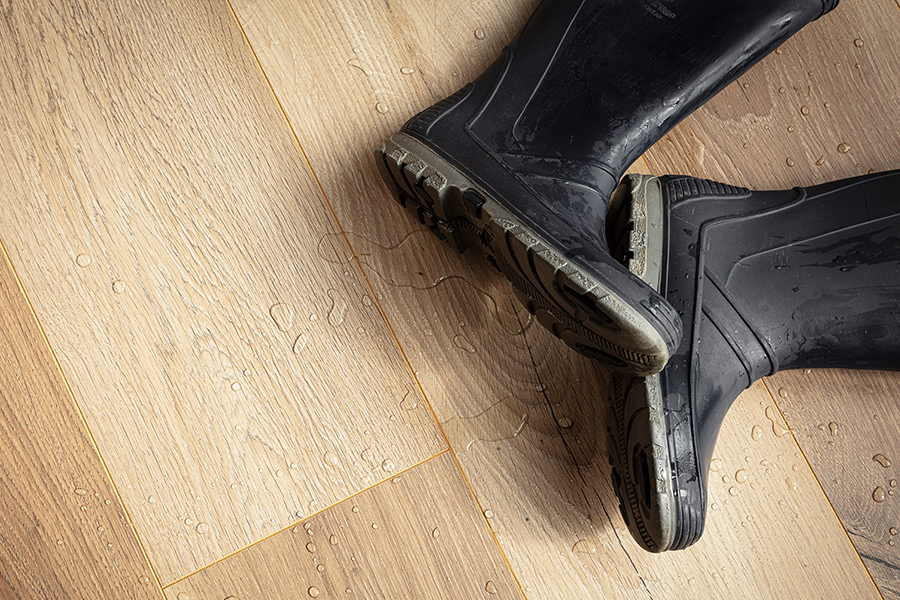 Classen AquaProtect laminatında su damcıları və rezin çəkmələr